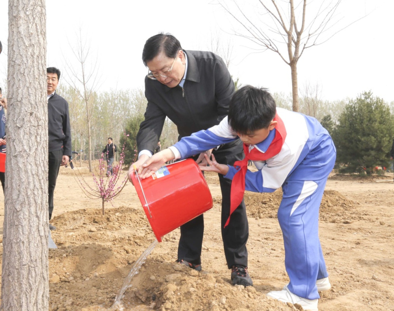这是张德江同少先队员一起给刚栽下的树苗浇水。新华社记者 丁林 摄